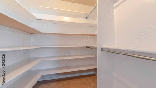 Panorama A white walk in closet with empty shelves