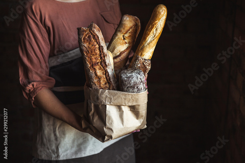 French baguettes in female hands on a black background. homemade baking photo