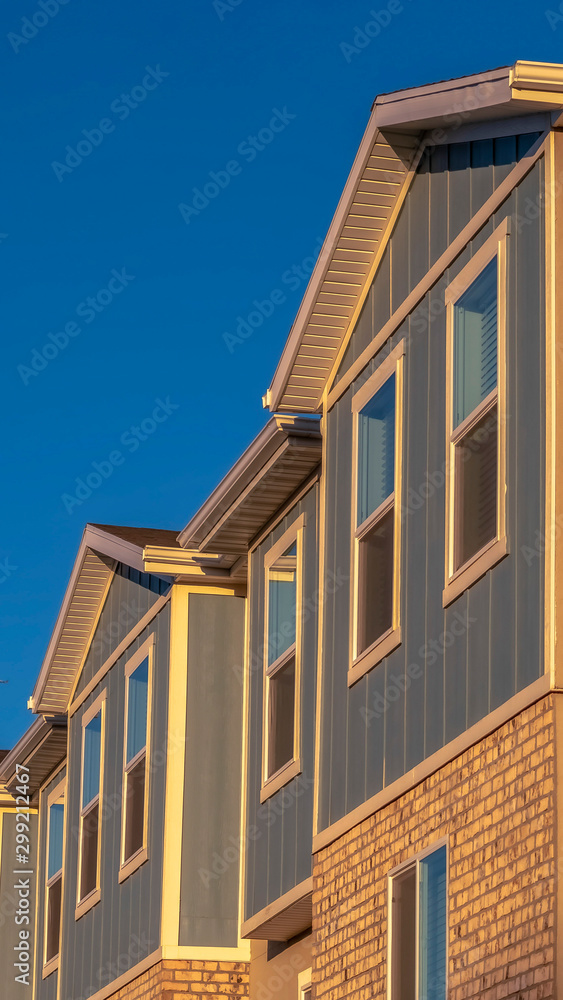 Vertical frame Townhomes on a neighborhood with vibrant blue sky background on a sunny day