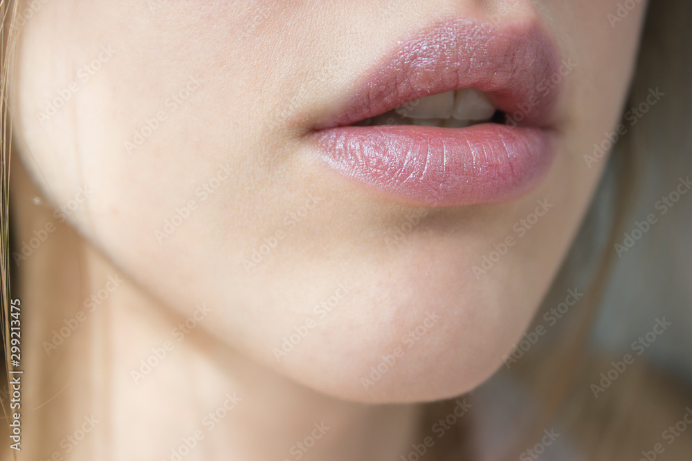 Obraz premium Young beautiful woman's lips view Nude lipstick/balm, lip care.Healthy skin, beauty concept