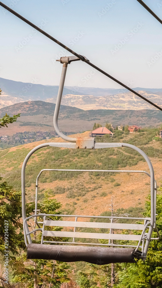 Vertical Focus on an empty chairlift against summer landscape of ski resort in Park City Vertical Focus on an empty chairlift against summer landscape of ski resort in Park City
