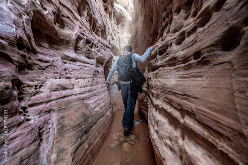 Man hiking through a narrow slot canyon in the Valley of Fire, near Las Vegas, Nevada, USA.