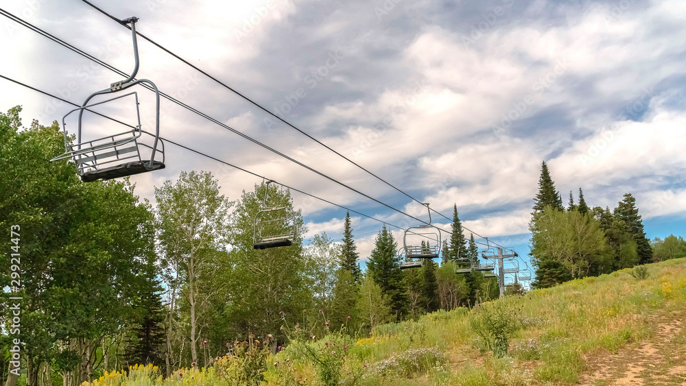 Fototapeta premium Panorama Chairlifts in Park City with a scenic aerial view of greenery during off season