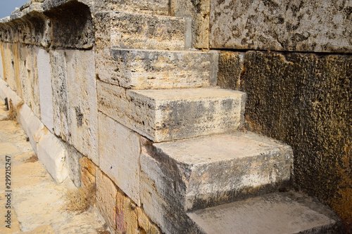 Fototapeta Naklejka Na Ścianę i Meble -  The steps of the amphitheater. Stone limestone and marble. Ancient antique amphitheater in city of Hierapolis in Turkey