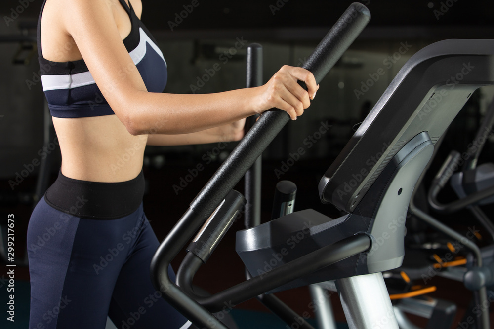 Fototapeta premium Asian slim Fitness woman black hair sport bra exercise warm up on push climbing machine elliptical cross in Fit Gym. Concept female Can Do athlete Sport healthy, half body no face