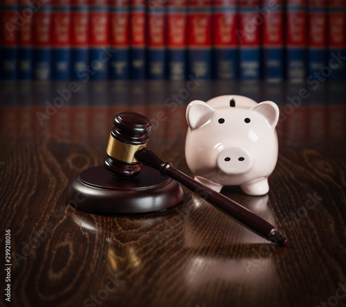 Gavel and Piggy Bank on Wooden Table With Law Books In Background photo