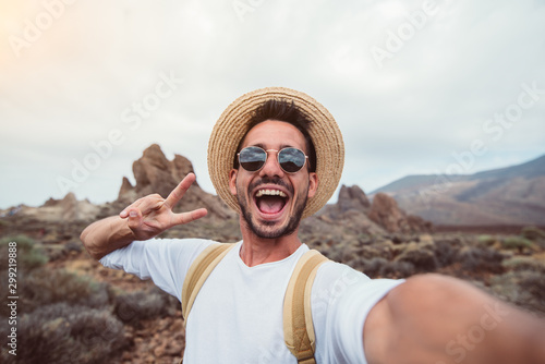 Handsome hiker taking a selfie hiking a mountain using his smartphone
