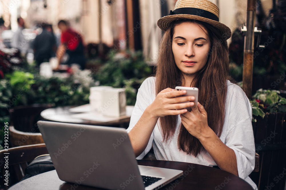 Beautiful woman work on laptop and using phone sitting in street cafe. Beautiful woman work on laptop and using phone sitting in street cafe.