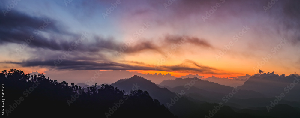 Sunset or sunrise mountain peaks colorful sky panorama.