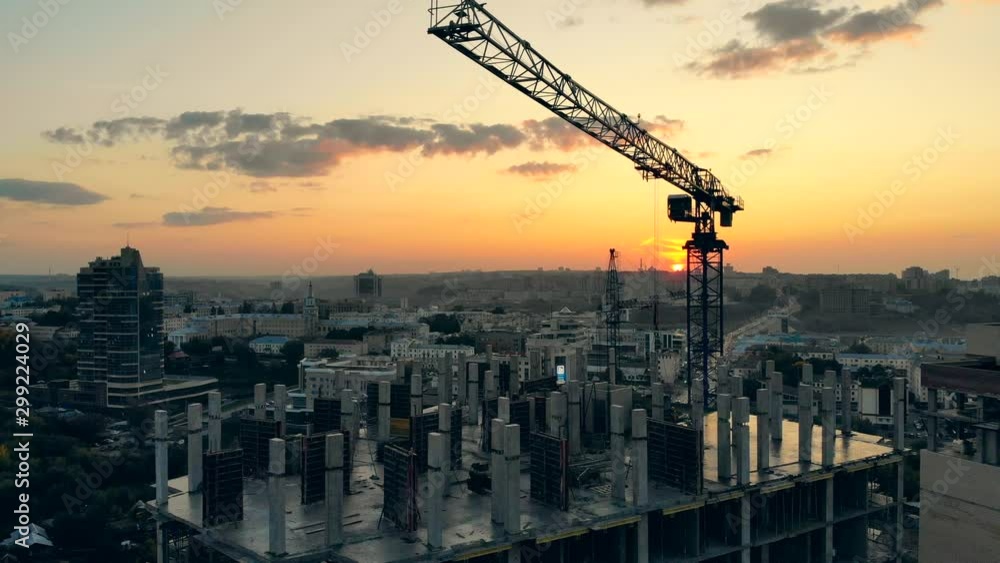 One crane working on building site, constructing a house.