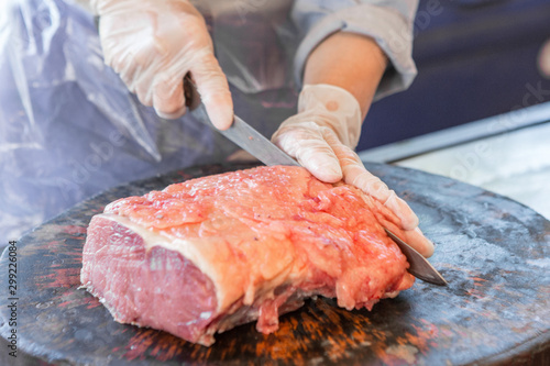 Merchants are slicing meat on the cutting board in the market