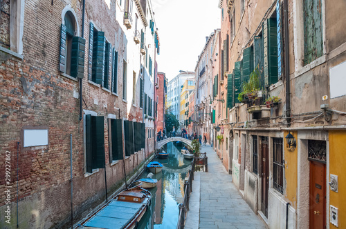 Narrow canal among old colorful brick houses in Venice, Italy. © naughtynut