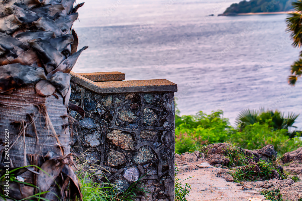 A stone wall with an ocean background.