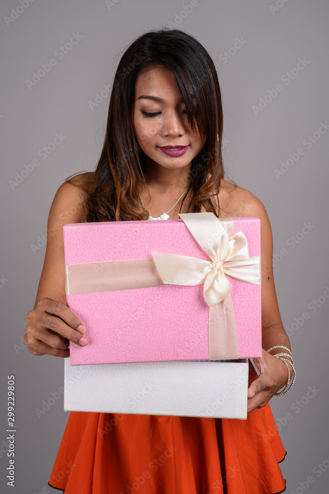 Portrait of Asian woman with wavy hair holding gift box Portrait of Asian woman with wavy hair holding gift box