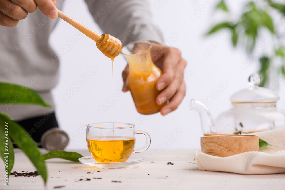Cropped image of arista pouring honey into cup of tea Cropped image of arista pouring honey into cup of tea