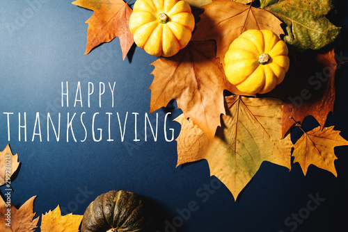 Happy Thanksgiving Day with maple leaves and pumpkin on blue background photo