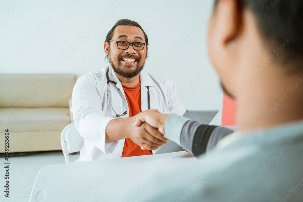 happy doctor and patient shake hand greeting in the clinic happy doctor and patient shake hand greeting in the clinic