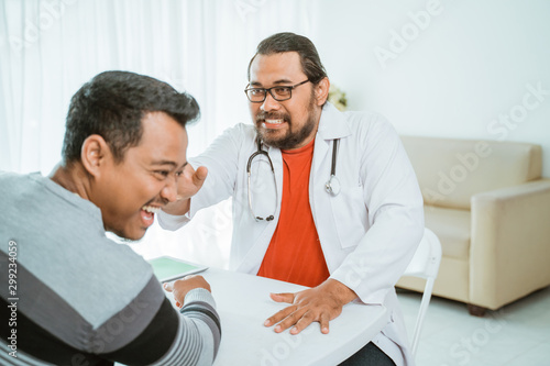 portrait of doctor push his patient head while in the clinic