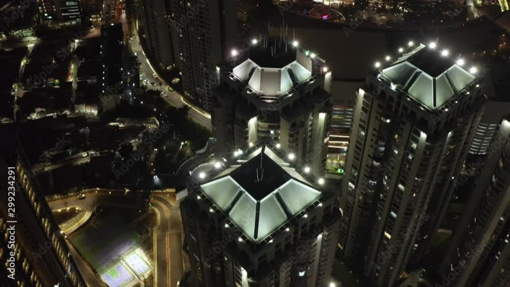 Aerial view above illuminated modern skyscraper cityscape towers at night. Architectural Tomang, Indonesia downtown urban scene. Aerial flyover.