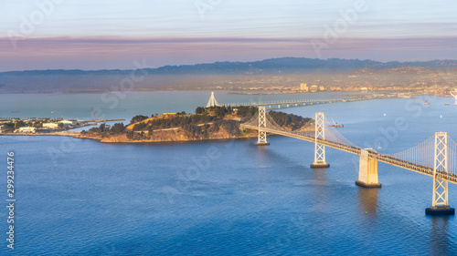 Photography Sunset view of Yerba Buena Island and the Bay Bridge; the smoke plume from Kinca
