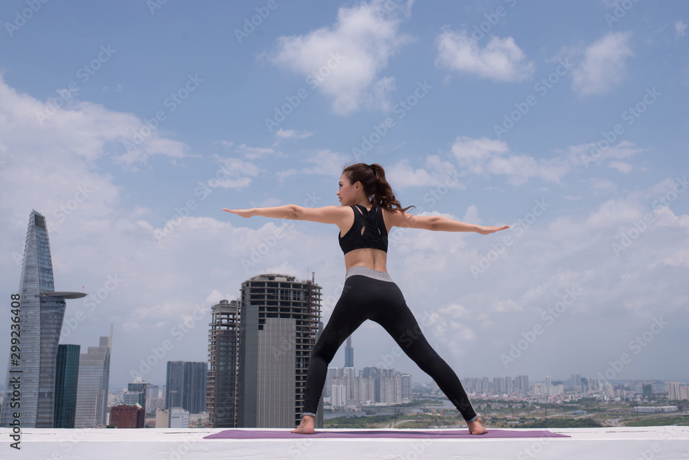 Young woman practicing yoga outdoor by blue sky, terrace Young woman practicing yoga outdoor by blue sky, terrace