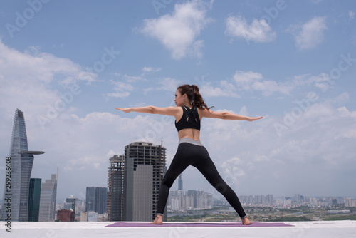 Young woman practicing yoga outdoor by blue sky  terrace