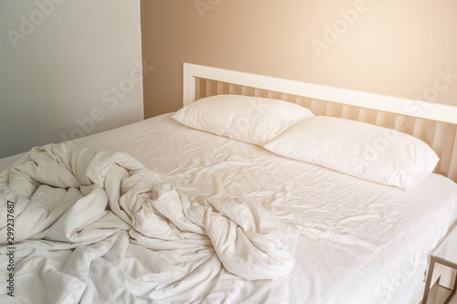 Fototapeta Naklejka Na Ścianę i Meble -  Two white pillow on bed with wrinkle messy blanket in bedroom