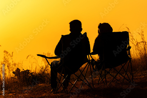 Picture of silhouette couple lovers watching sunrise among fog