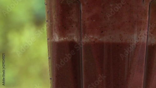 Handheld, close up shot of red juice being pulsed in a blender.