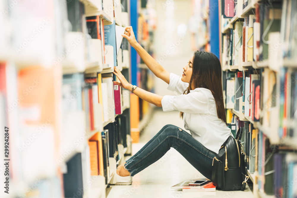 Beautiful female choosing novel on shelf in bookstore, Young Asian woman college student taking book on bookshelf in university campus library, Lifestyle Asia people education, casual studying concept Beautiful female choosing novel on shelf in bookstore, Young Asian woman college student taking book on bookshelf in university campus library, Lifestyle Asia people education, casual studying concept