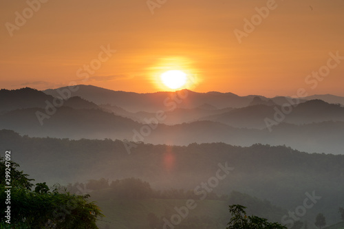 Morning mist covered on hill after sunrise at tropical forest. Thailand