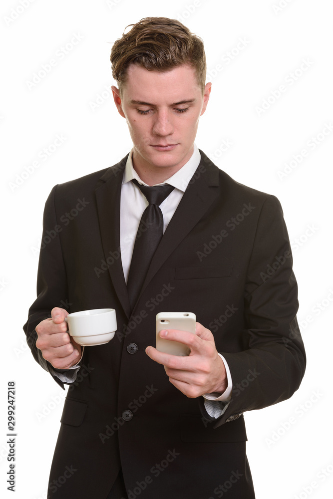 Young handsome blonde businessman holding coffee cup while using phone Young handsome blonde businessman holding coffee cup while using phone