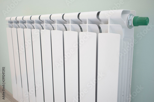 Radiator with thermostat valve isolated on green background photo