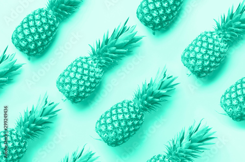 Fresh pineapples on mint color background. Top View. Pop art design, creative concept. Trendy green and turquoise color. Bright pineapple pattern for minimal style.