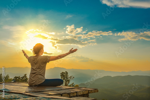 Healthy woman lifestyle balanced practicing meditate and zen energy yoga outdoors on the bridge in morning the mountain nature. Healthy life Concept.