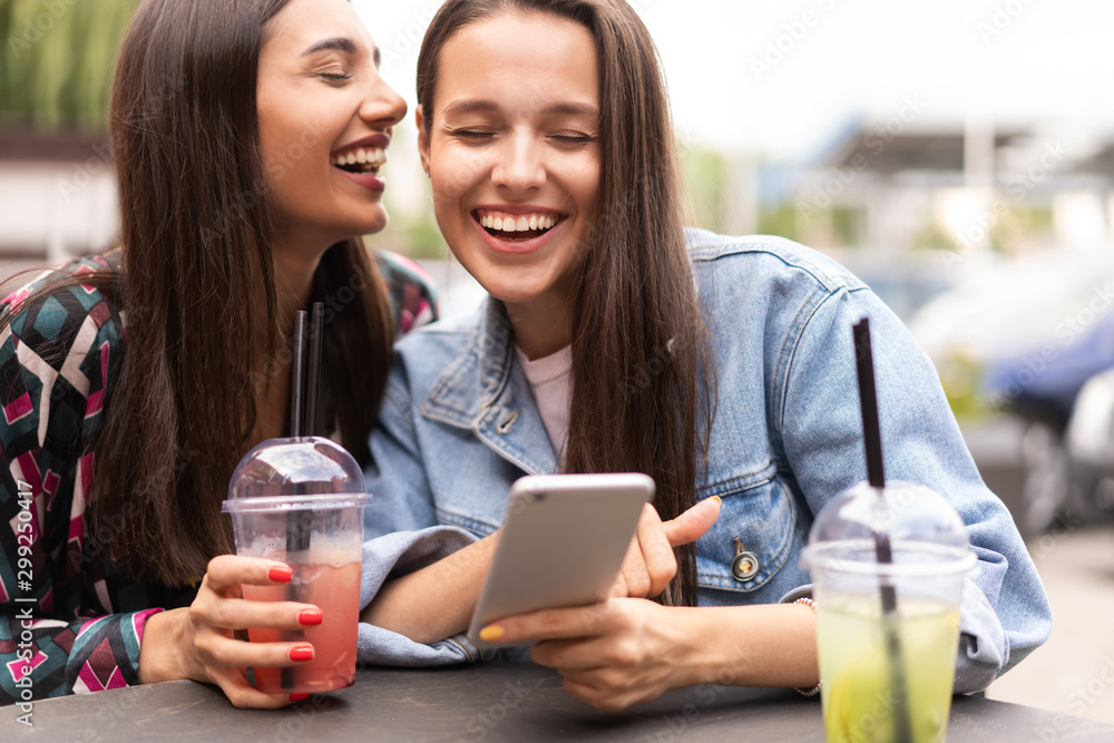 Young girls friends watch something in smartphone. Young girls friends watch something in smartphone.