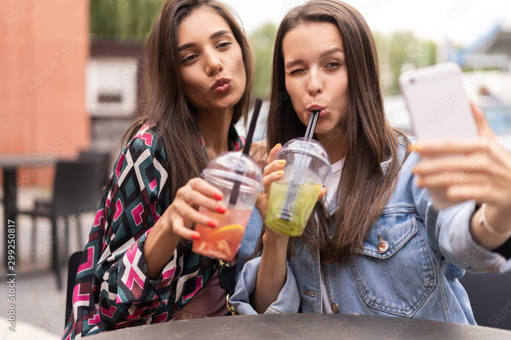 Close up lifestyle selfie portrait of pretty fresh young brunette best friends girls making selfie, having fun Close up lifestyle selfie portrait of pretty fresh young brunette best friends girls making selfie, having fun