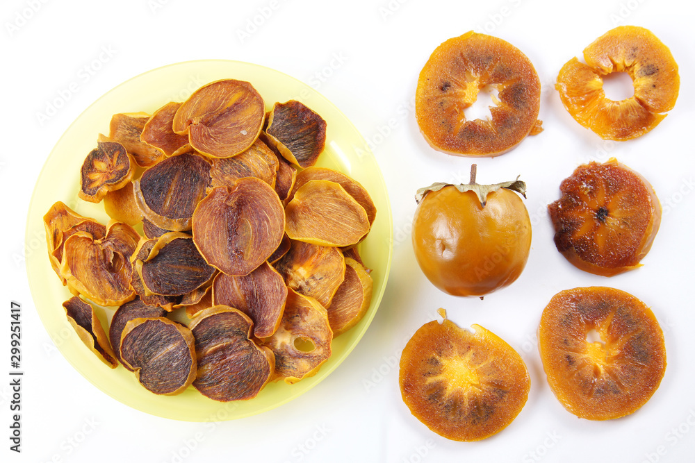 Ingredients for healthy fruit chips made of persimmon on white background. Vegetarian dietary food Ingredients for healthy fruit chips made of persimmon on white background. Vegetarian dietary food