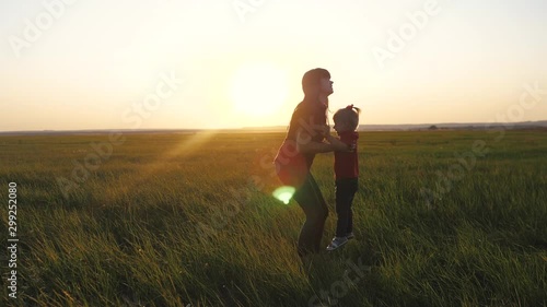 Wallpaper Mural happy family funny a mom holds daughter circling is playing silhouette at sunset slow motion. little girl and woman mom play have fun outdoors sunlight on the field outdoors. teamwork happy family mom Torontodigital.ca