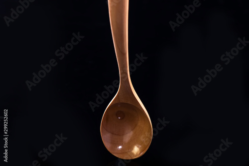 The wooden spoon on black blackground