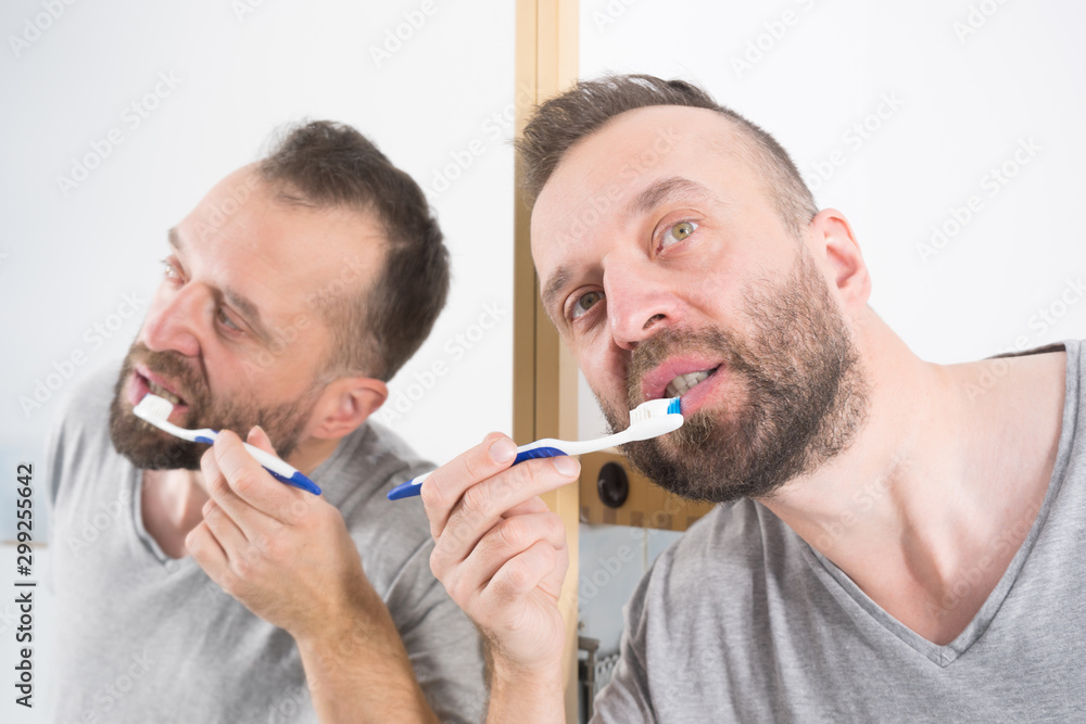 Fototapeta premium Man brushing his teeth in bathroom
