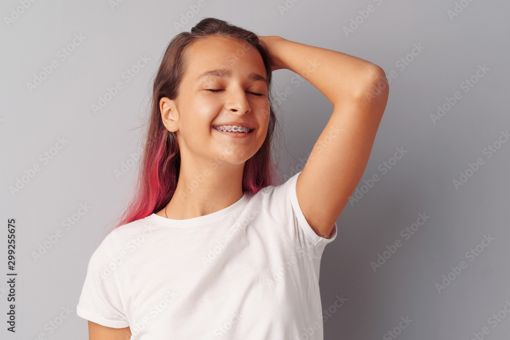 Young girl teenager with pink hair happy and smiling over gray background Young girl teenager with pink hair happy and smiling over gray background