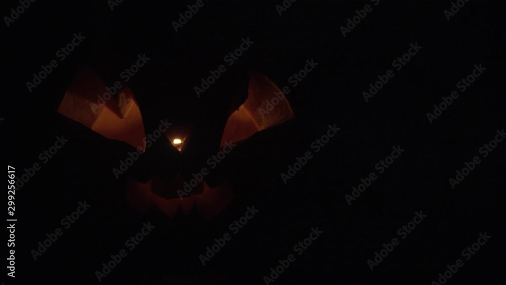 Pumpkin for Halloween with a sinister face flickers with an orange light Pumpkin for Halloween with a sinister face flickers with an orange light