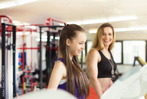 Mother and daughter training. Beautiful mature woman and her teenage daughter in the gym
