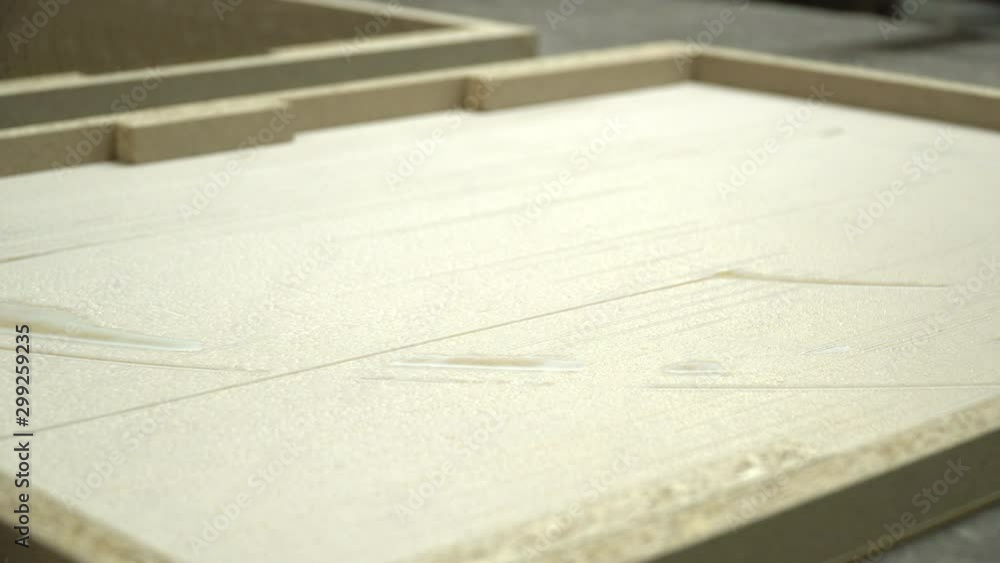 Close up on gluing furniture components. Using glued HDF board, chipboard frame, honeycomb paper insertion on press line. Close up on gluing furniture components. Using glued HDF board, chipboard frame, honeycomb paper insertion on press line.