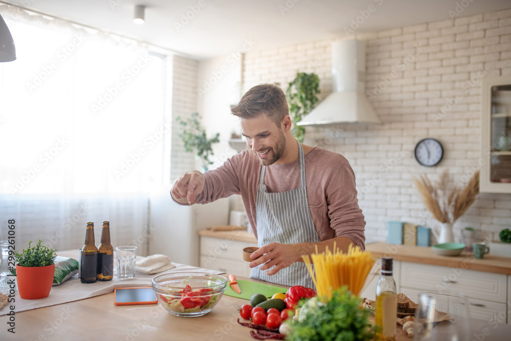 Smiling businessman enjoying weekend cooking at home Smiling businessman enjoying weekend cooking at home