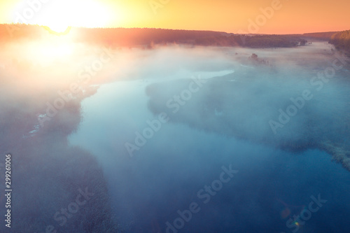 Early misty morning. Sunrise over the lake. Rural landscape in summer. Aerial view