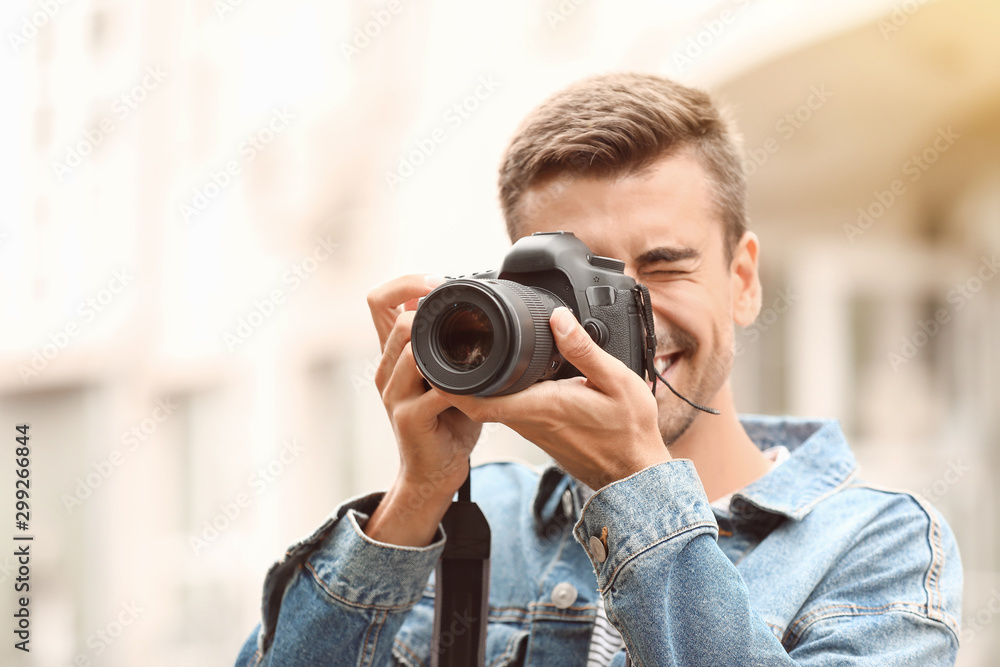 Young male photographer with camera outdoors - obrazy, fototapety, plakaty 