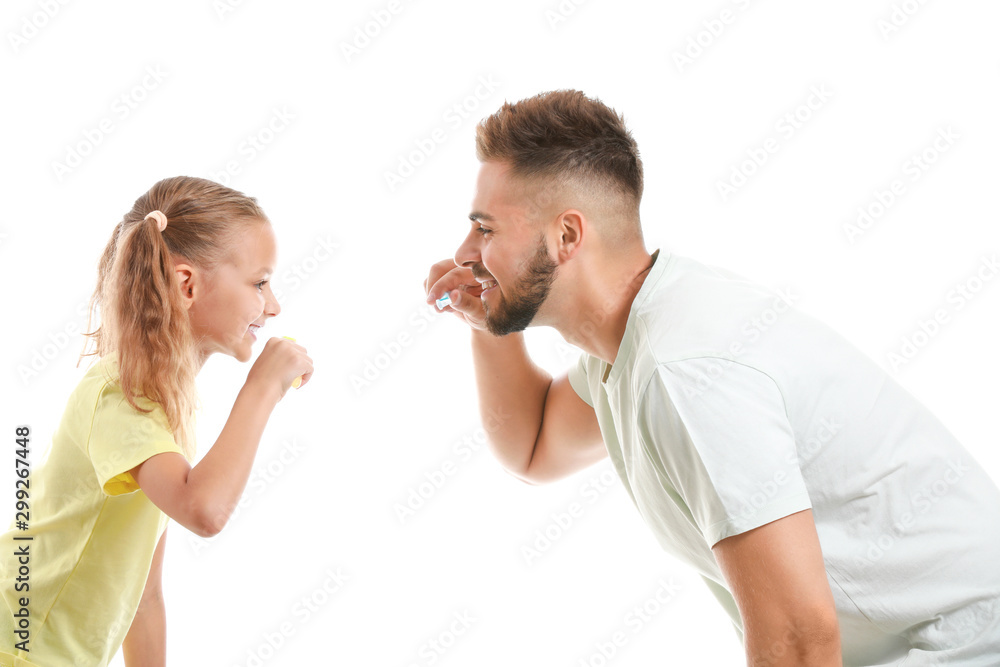 Portrait of father and his little daughter brushing teeth on white background Portrait of father and his little daughter brushing teeth on white background