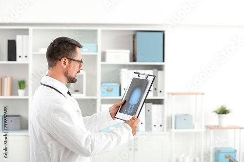 Portrait of male doctor with x-ray image in clinic